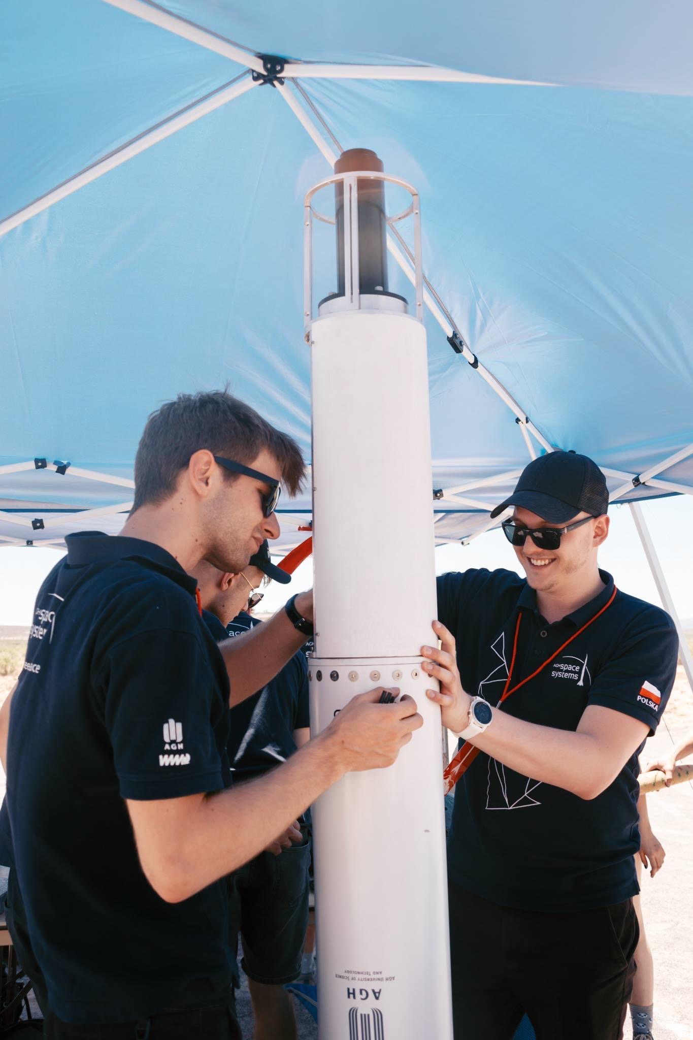 Piotr Wolanski assembling an AGH Space Systems rocket in the field